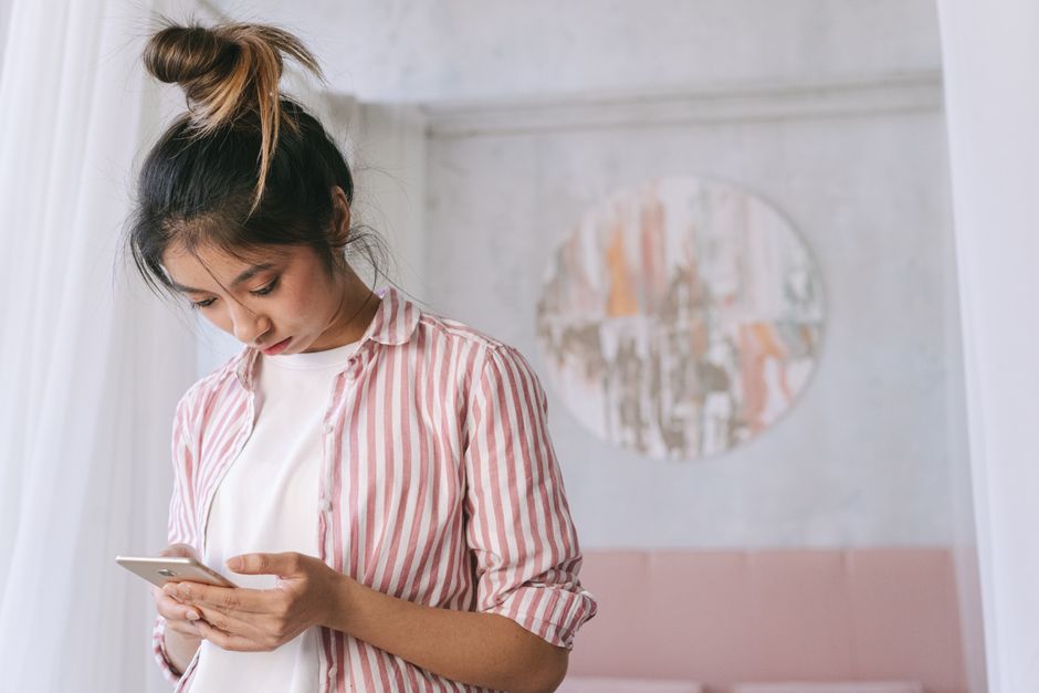 スマートフォンの表示を待つ女性